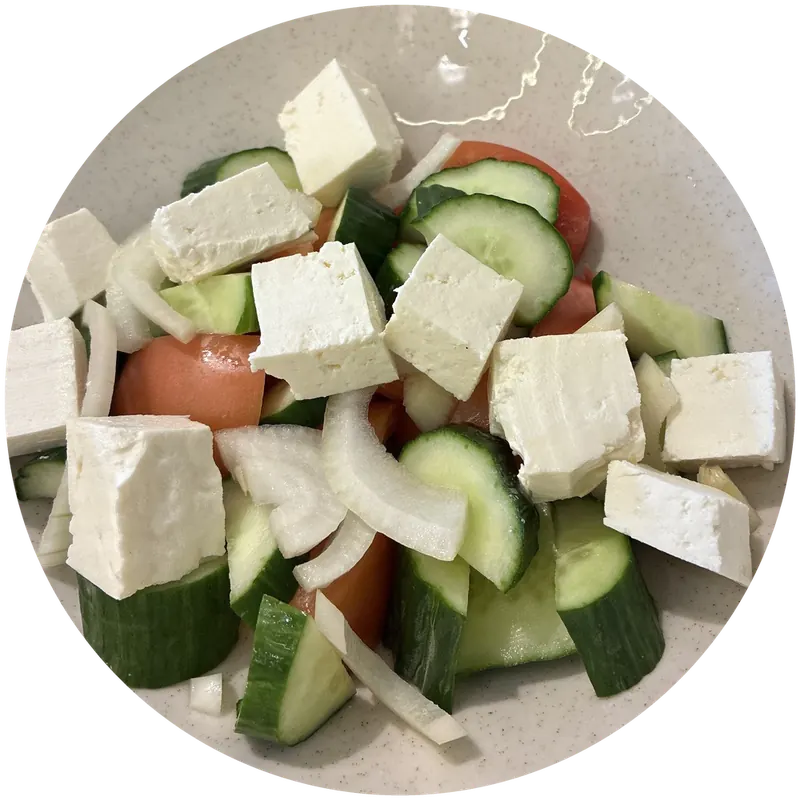 Greek salad with cubes of white cheese, cucumber, tomato and onion